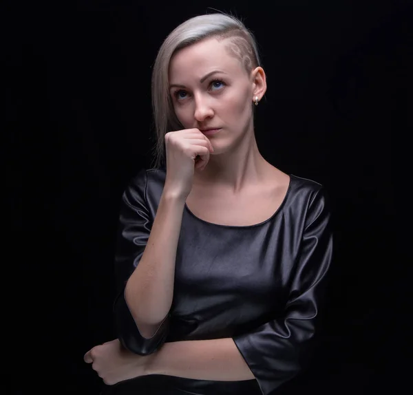 Thinking blond woman in leather dress — Stock Photo, Image