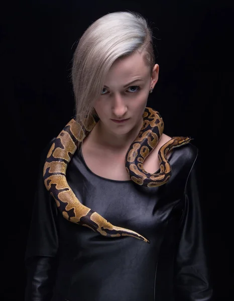 Woman in leather dress and royal python — Stock Photo, Image