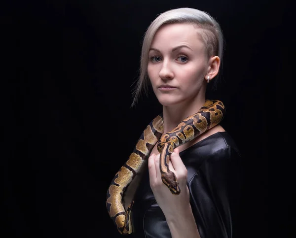 Woman in leather dress with ball python — Stock Photo, Image