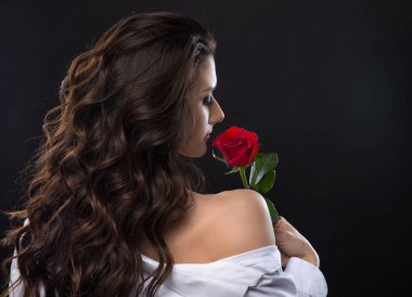 Güzel esmer kadın kırmızı gül koklama