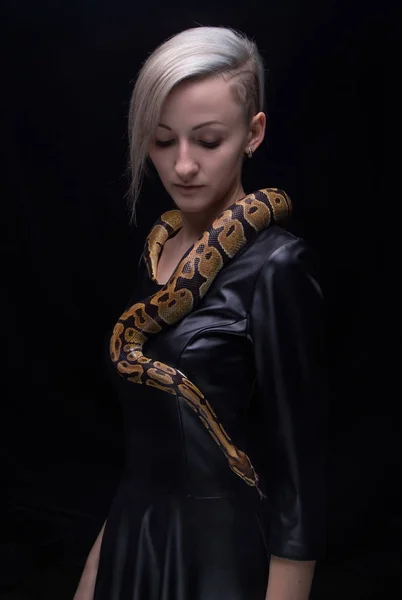 Woman in leather dress with python