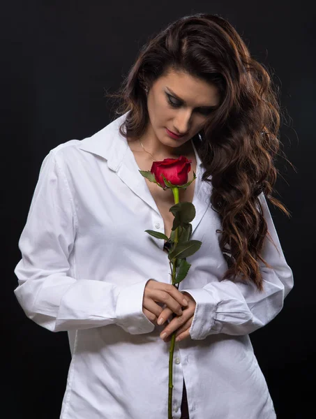 Bruna donna riccia con rosa rossa — Foto Stock