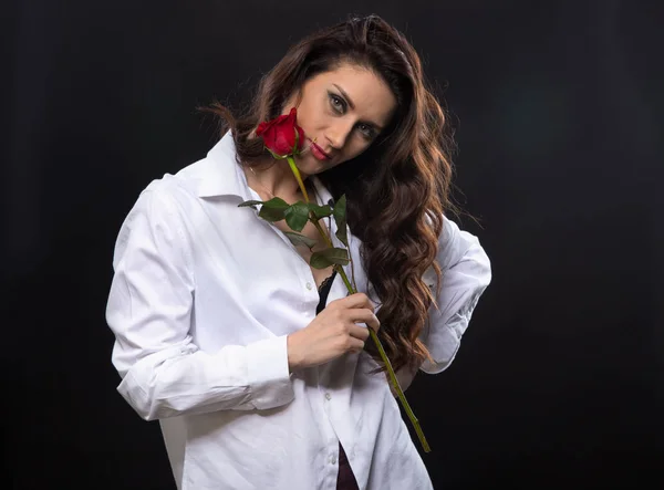Молода брюнетка, що тримає червону троянду — стокове фото