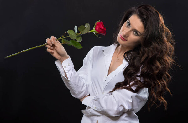 Attractive brunette woman with red rose