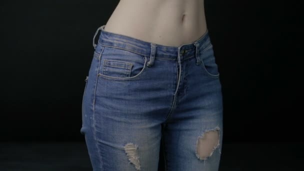 Тонкая женщина раздевает синие джинсы — стоковое видео