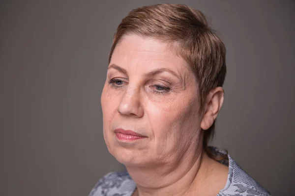 Portrait of old woman looking down — Stock Photo, Image