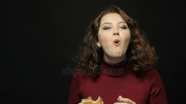 Брюнетка ест гамбургер, снимает крупным планом — стоковое видео