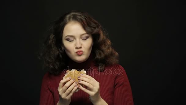 Νεαρή γυναίκα τρώει χάμπουργκερ, closeup, σκοποβολή — Αρχείο Βίντεο