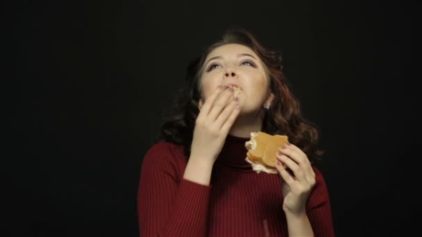 Mladá žena jíst hamburger, closeup, Střelba — Stock video