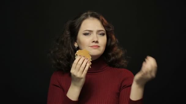 Mujer comiendo hamburguesa con queso, disparando de cerca — Vídeos de Stock