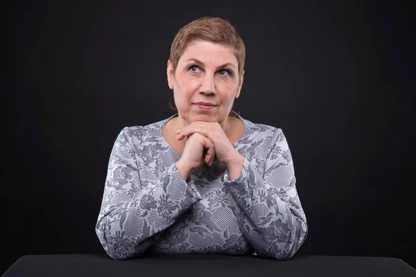Portrait of sitting thinking senior woman — Stock Photo, Image