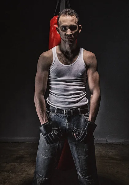 Photo of aggressive athlete and red boxing bag — Stock Photo, Image