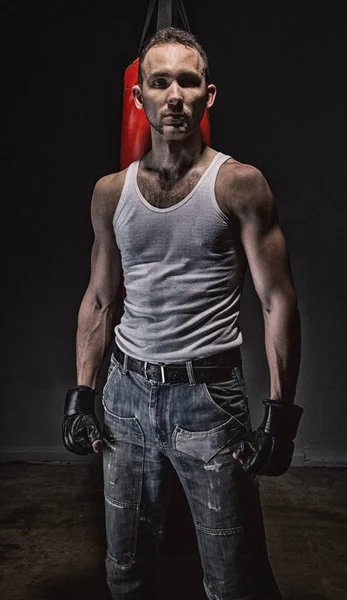 Serious athlete and red boxing bag — Stock Photo, Image