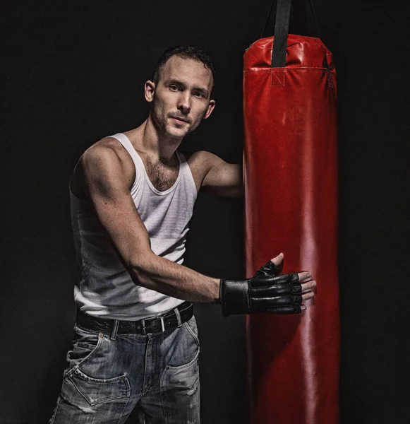 Hombre boxeador cansado y bolsa de boxeo roja —  Fotos de Stock