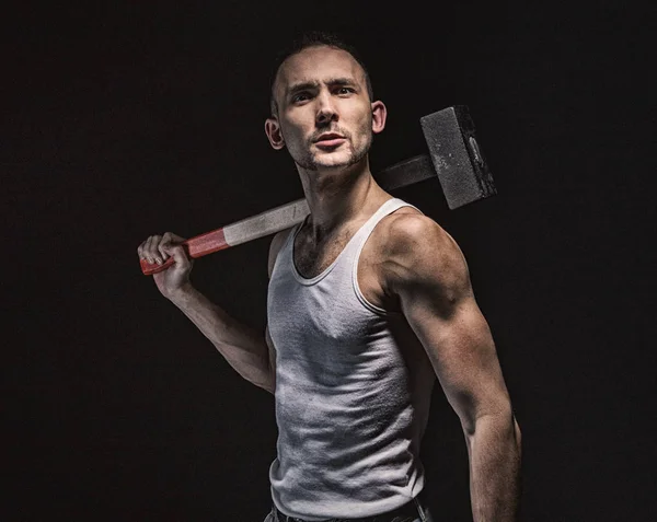 Brunette muscular man with hammer — Stock Photo, Image