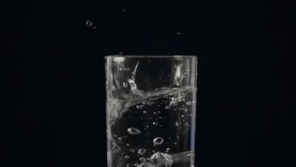 Vaso de agua y cubo de hielo que cae — Vídeo de stock