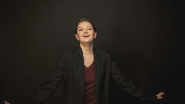 Gelukkig dansende vrouw in zwarte jas — Stockvideo