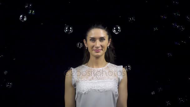 Красива усміхнена жінка і падаючі мильні бульбашки — стокове відео