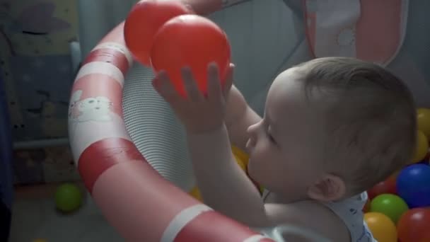 Baby playing with color balls in playpen — Stock Video