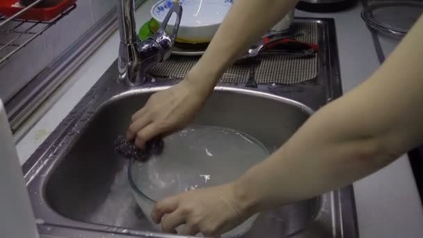 Vrouw wassen en spoelen glazen schotel — Stockvideo