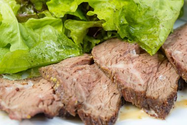 Tuzlu pişmiş dana dilimleri ve yeşil sebzeler