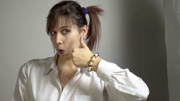 Šklebící se mladá žena ukazuje palec — Stock video