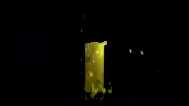 Falling fake ice in orange juice — Stock Video