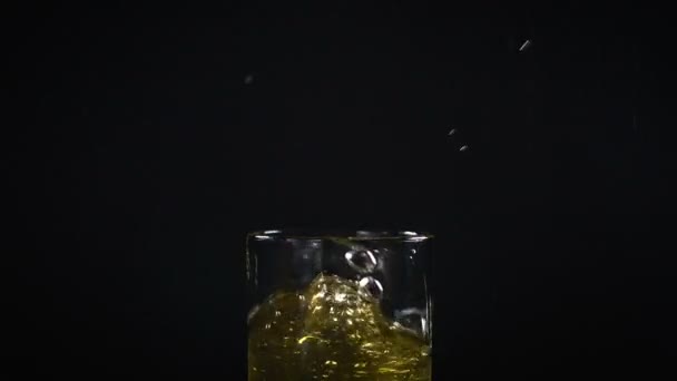 Падающий кубик льда и фруктовый сок — стоковое видео