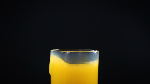 Падающий лёд и апельсиновый сок — стоковое видео
