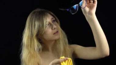 Sarışın genç kadın gözlük silme