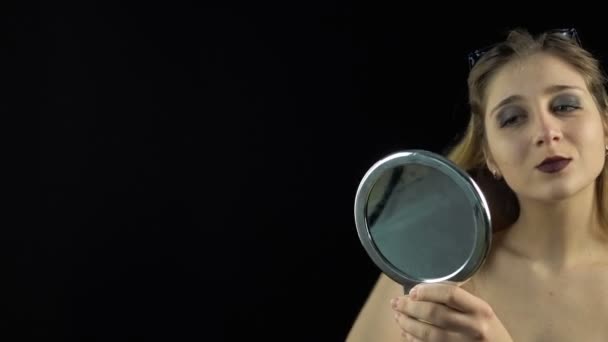 Глядя на зеркало молодой девушки — стоковое видео