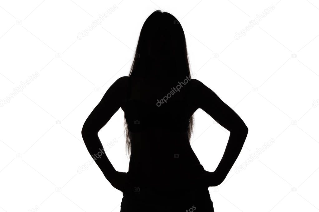 Silhouette of girl with hands on hips