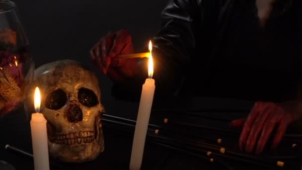 Женщина в капюшоне зажигает свечи — стоковое видео