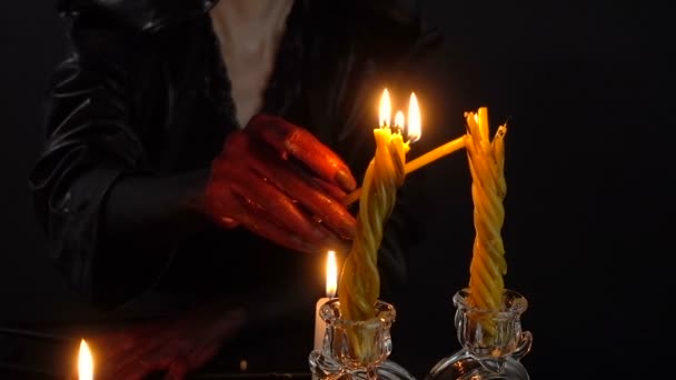 Женщина с кровавыми руками зажигает свечи — стоковое видео