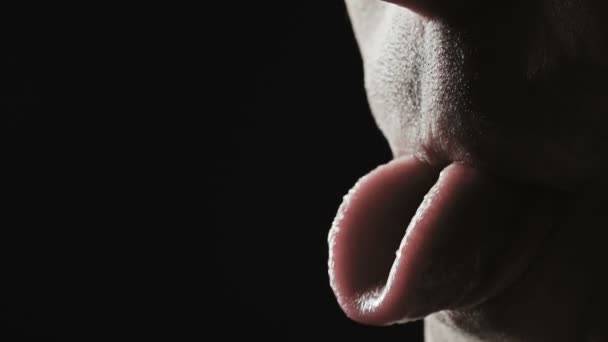Крупним планом зйомки чоловіка гризе язиком — стокове відео