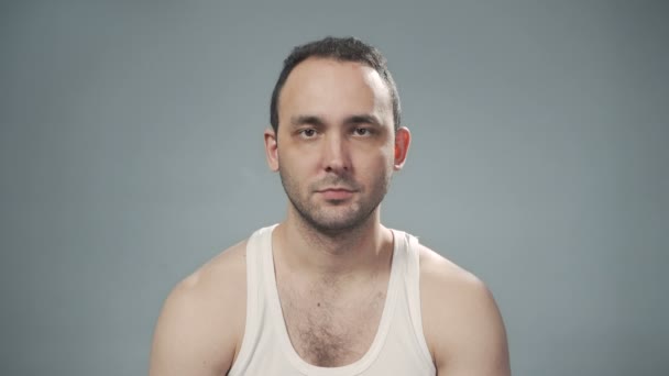 Video de un hombre serio sin afeitar sobre fondo gris — Vídeo de stock