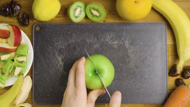 Video de manzanas verdes cortando en pizarra negra — Vídeo de stock
