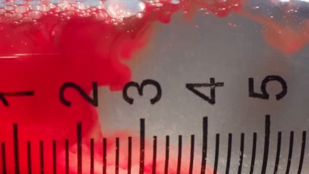 Макровидео медицинского шприца с кровью в жидкости — стоковое видео