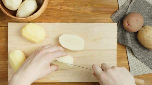 Съемка приготовления картофеля для выпечки на деревянной доске — стоковое видео