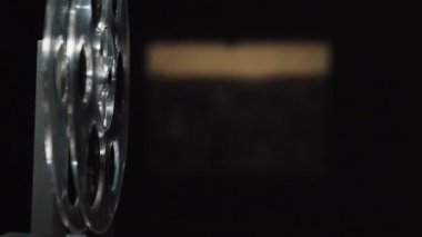 Siyah arkaplanda çekim yapan eski film projektörü