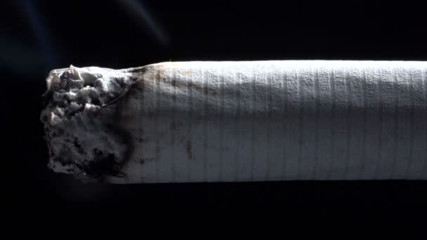 Macro filmagem de cigarro em chamas no fundo preto — Vídeo de Stock