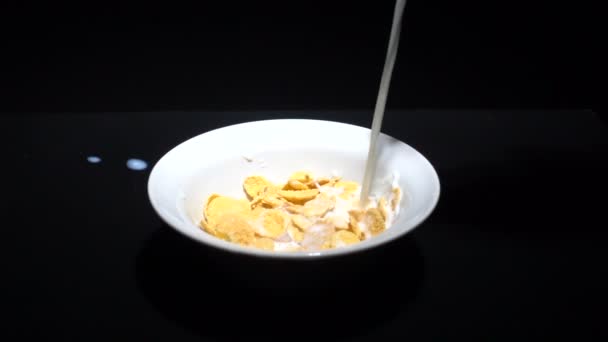 Видео медленного наливания молока в хлопья кукурузы — стоковое видео