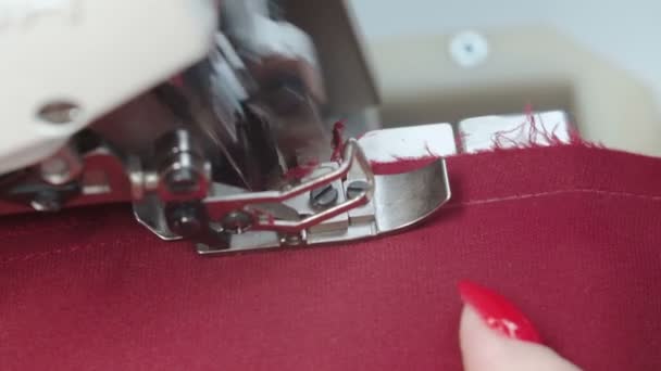 Vídeo de la mujer sastre cosiendo ropa en overlock eléctrico — Vídeo de stock