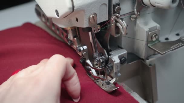 Shooting of tailor sewing clothes on electric overlock — Stock Video