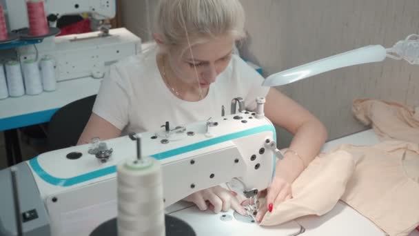 Video de la joven costurera vestido en la máquina eléctrica en el taller — Vídeos de Stock