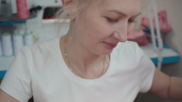 Tailor blond žena šití kalhotky na elektrický stroj v dílně — Stock video