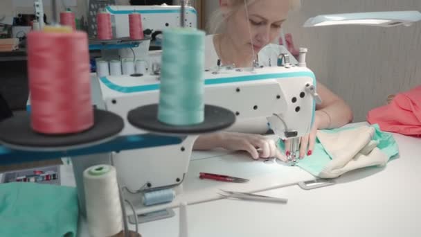 전자 기계에 부착되어 있는 재단사의 여성 재봉틀 상표를 보여 주는 비디오 — 비디오