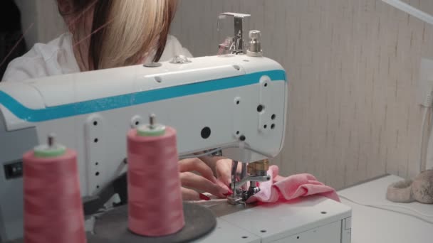 Видео, как брюнетка шьет заказ на машине на фабрике — стоковое видео