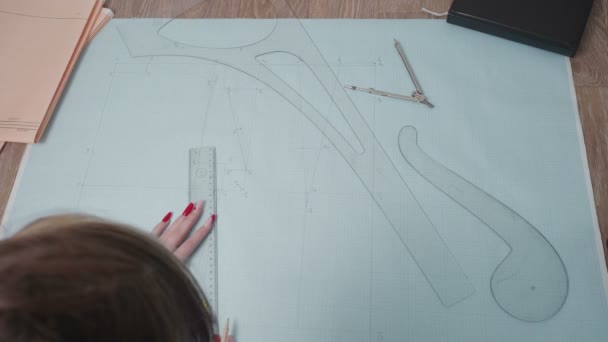 Vídeo de la curva de dibujo de mujer sobre papel en taller — Vídeo de stock