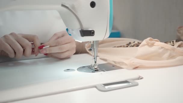 Видео, как портная шьет одежду на электрической машине в мастерской — стоковое видео
